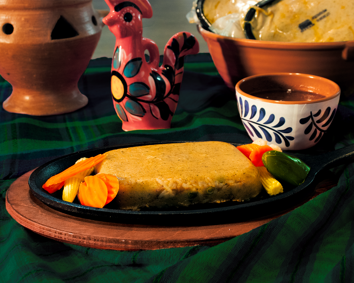 mexican central american style tamale nacatamal with olives green peas rice and garbanzo high protein served with encurtido and salsa
